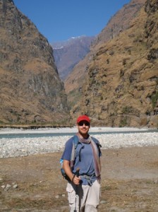 Scott on the river flood plain, more mountains in the background