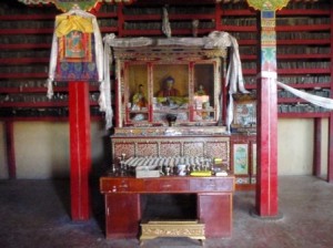 An altar in the Narthang Monastery; the library of scripture printing tablets in the background.